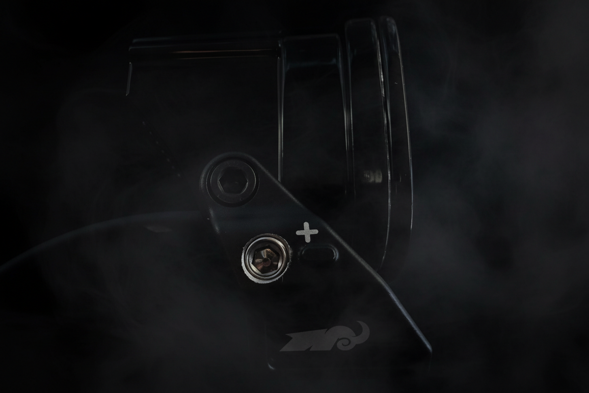 Close-up of a black off road light with visible branding on a dark background