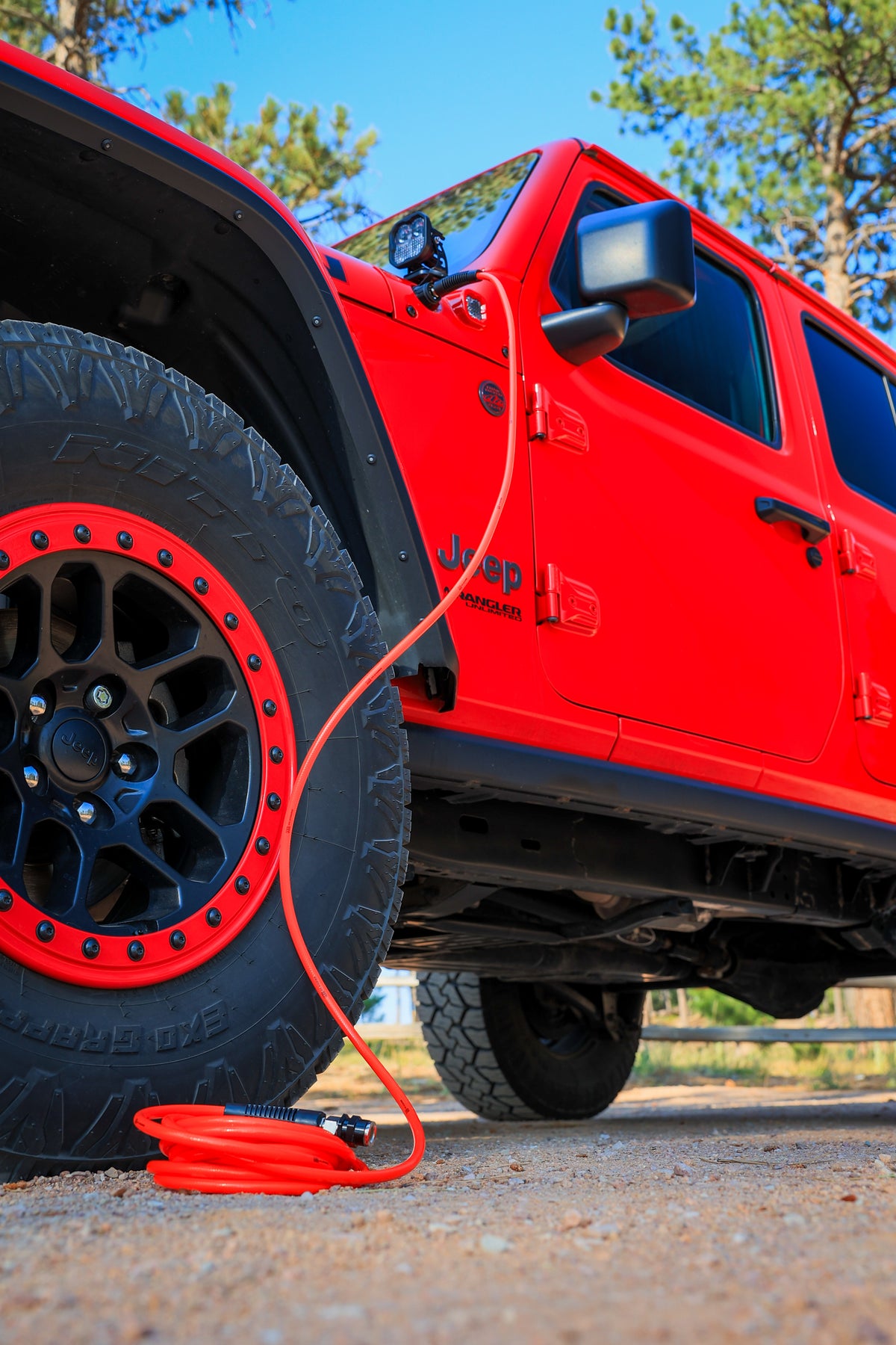 A long orange air hose is connected to Insight Fusion Air, for refilling the tires after off roading.  